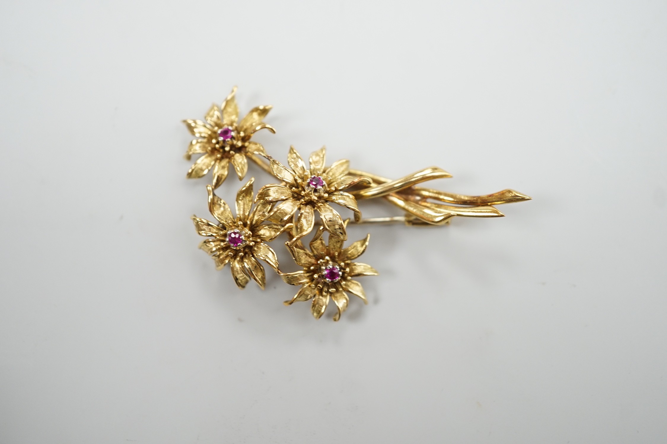 A 1960's 18ct gold and four stone ruby set floral spray brooch, 50mm